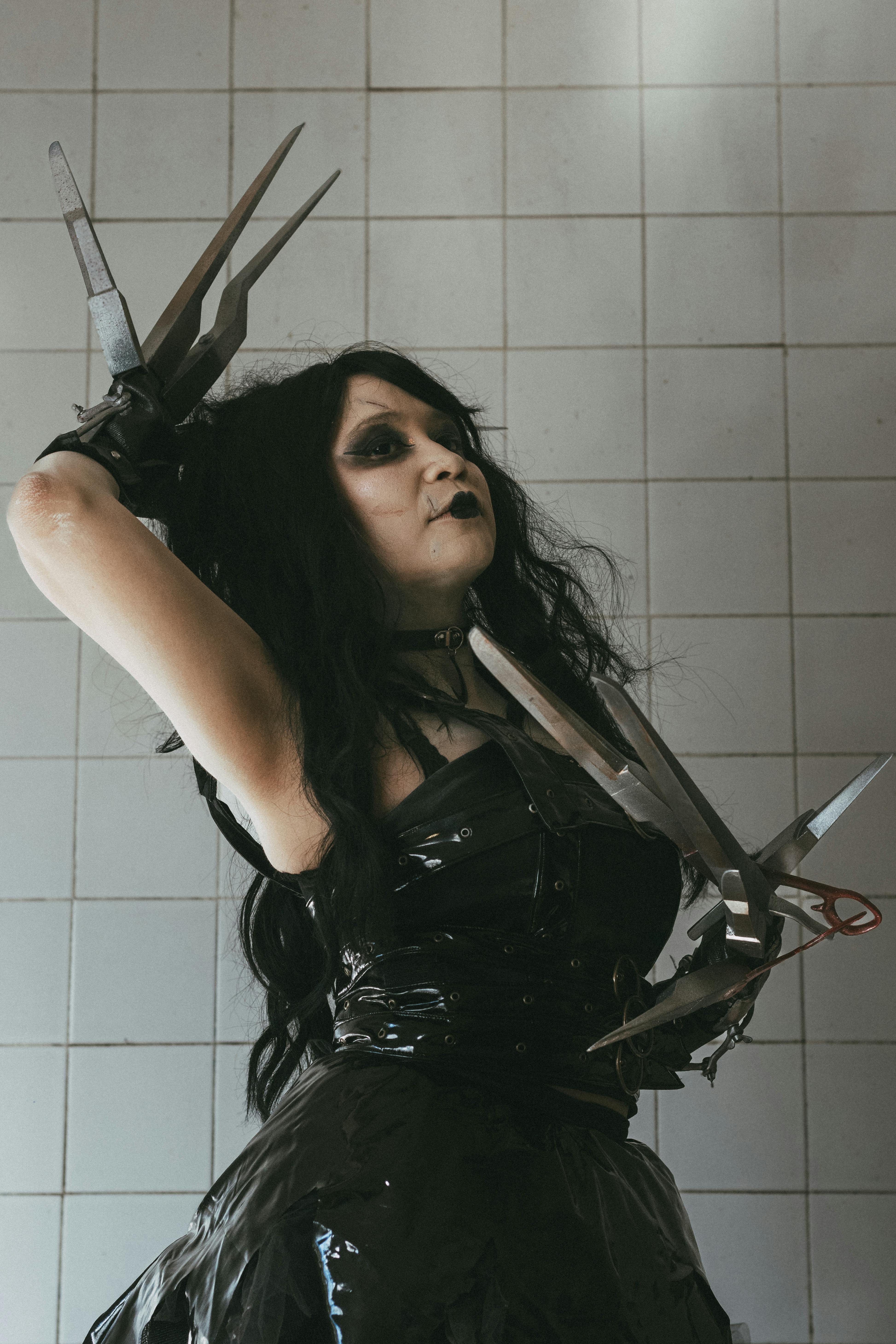 Dark-themed cosplay with gothic makeup and costume, photographed indoors.
