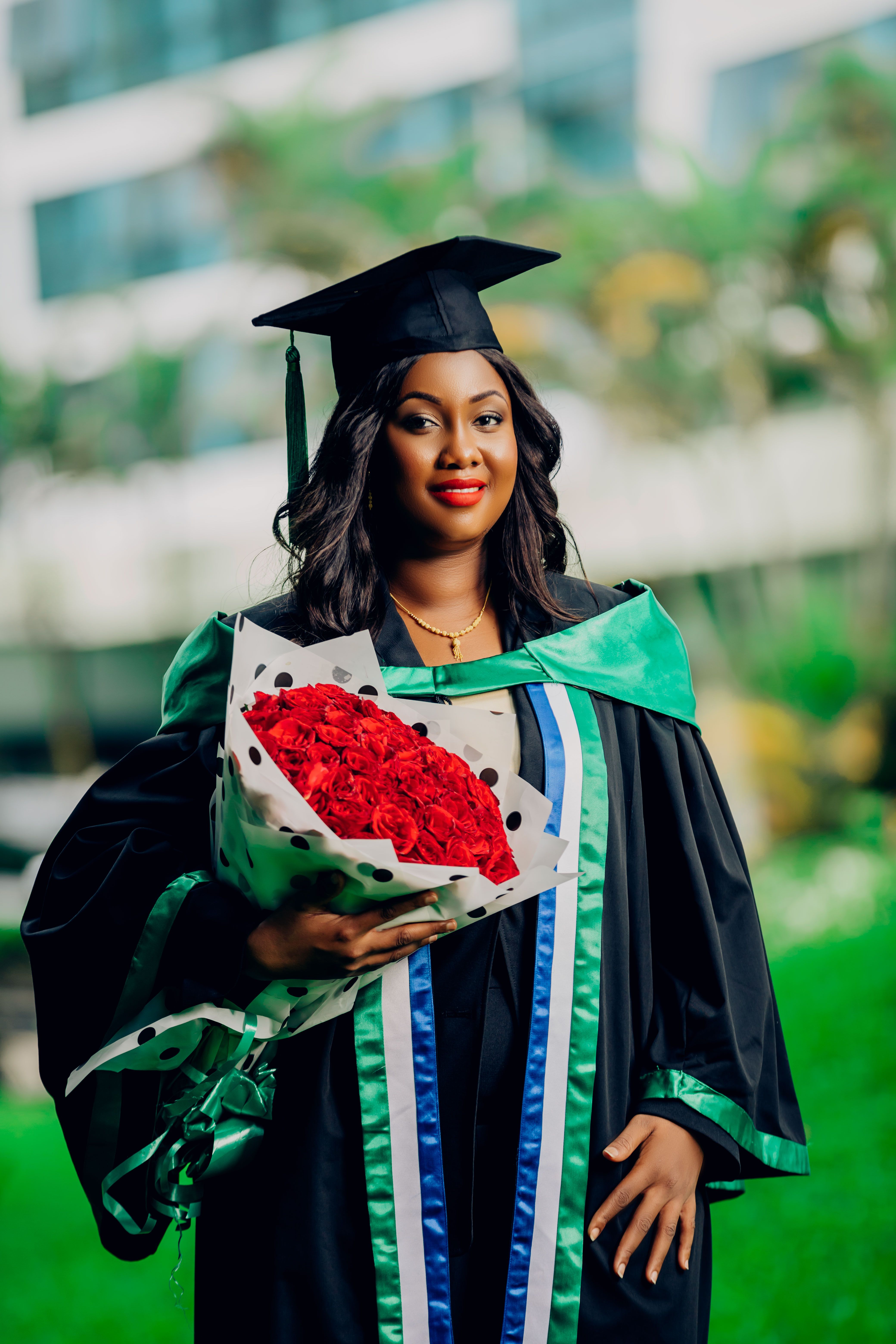 Joyful Graduate Holding Bouquet in Cap and Gown · Free Stock Photo