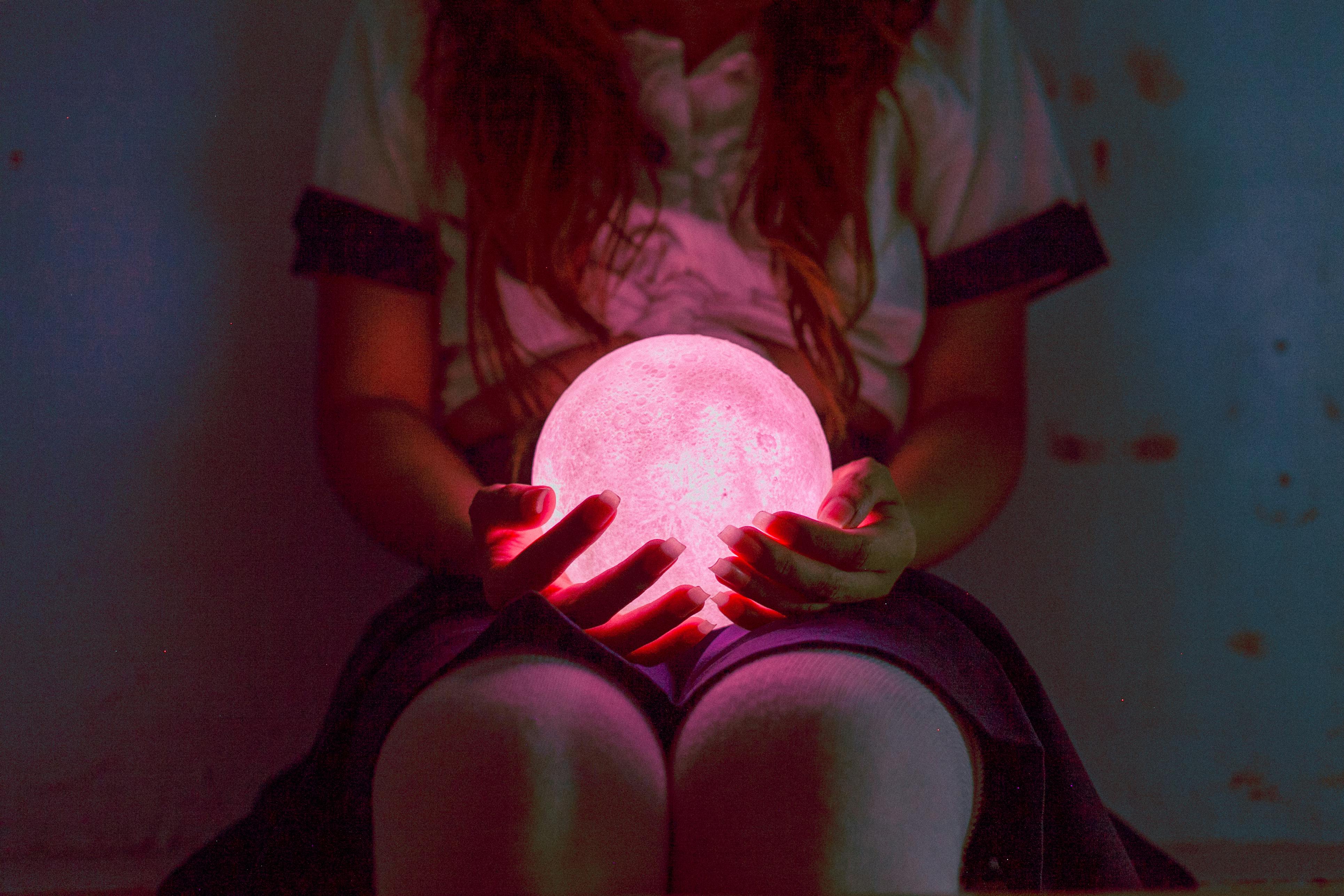 person holding ball night lamp while sitting
