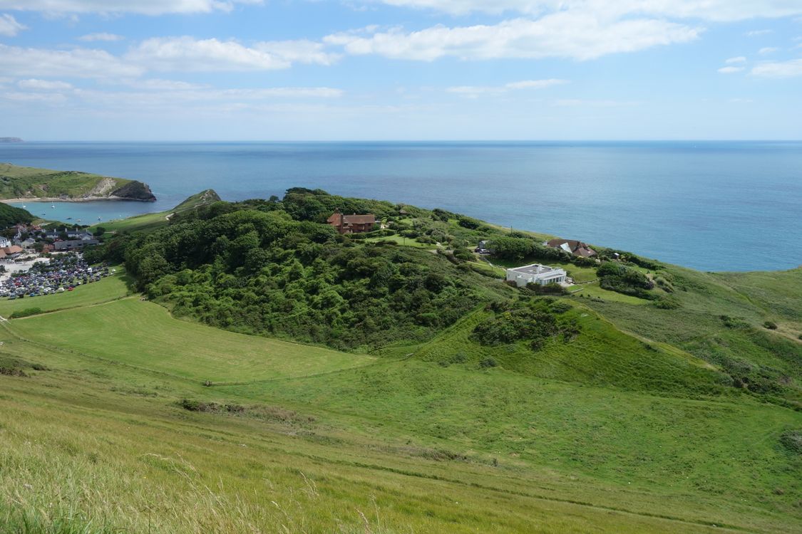 Scenic Coastal Landscape with Green Hills and Ocean · Free Stock Photo