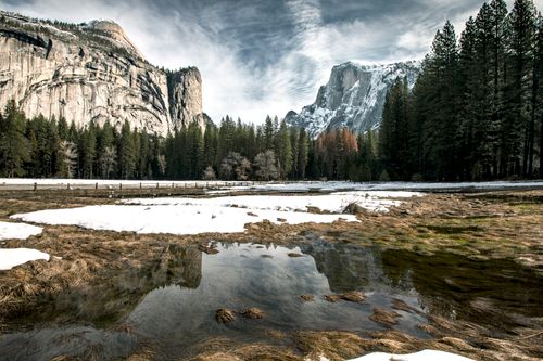 Free Serene winter landscape in Yosemite, showcasing snow-covered meadows and majestic cliffs. Stock Photo