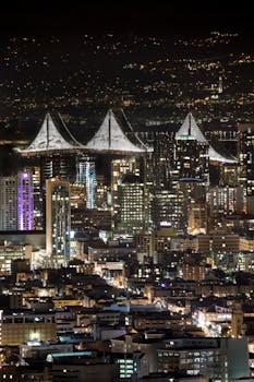 A breathtaking view of San Francisco's skyline illuminated at night featuring the iconic Bay Bridge.
