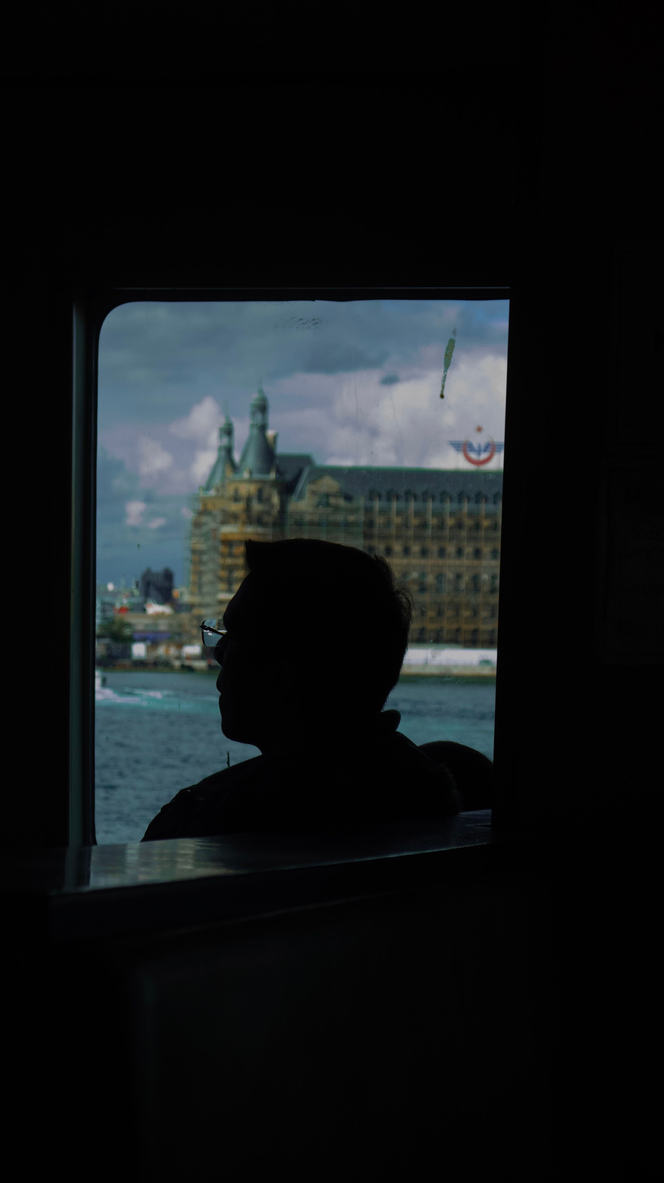 Silhouette of a Man on a Boat with City Skyline · Free Stock Photo