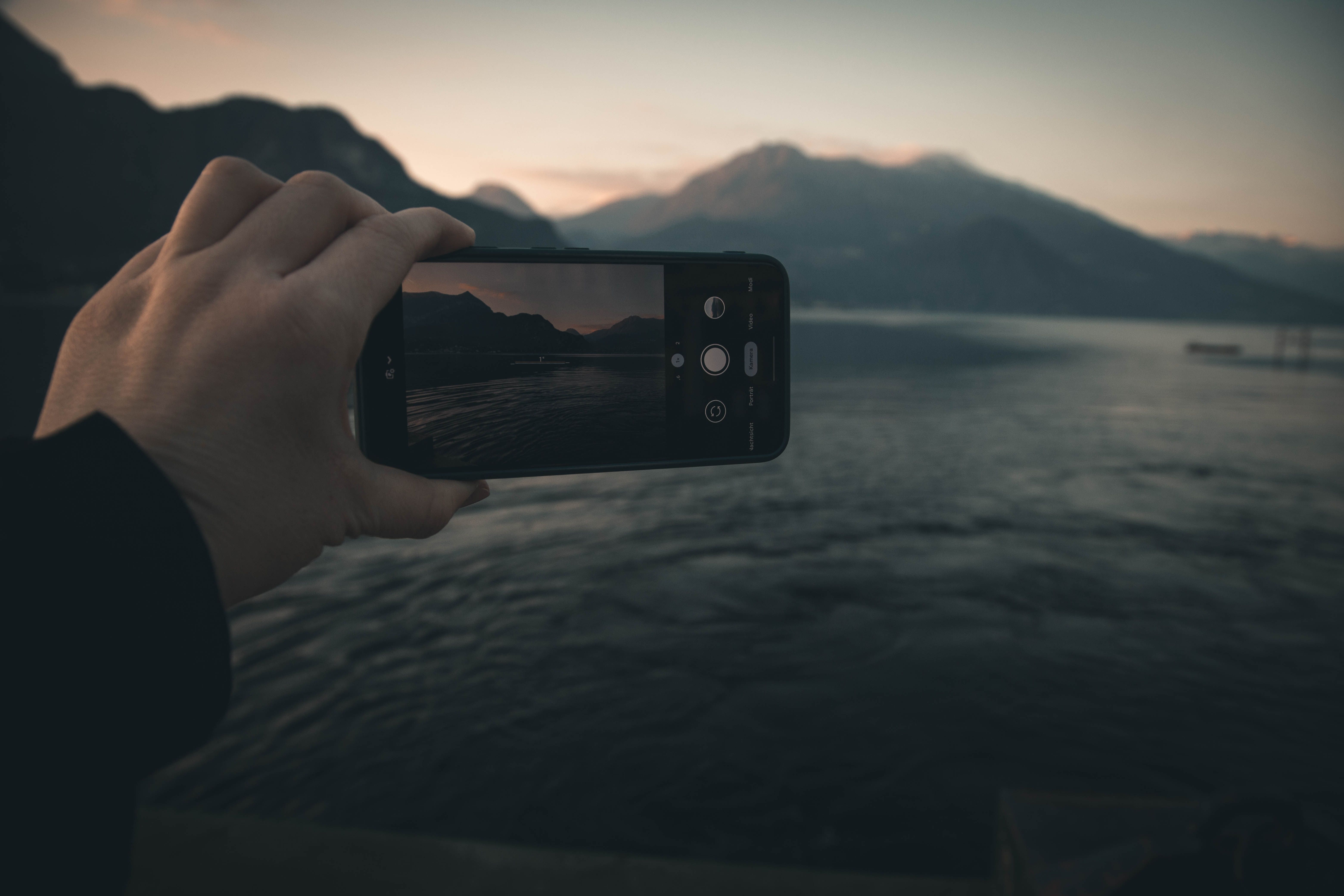 A smartphone capturing a picturesque view of Lake Como at dusk, perfect for travel enthusiasts.