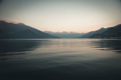Free Captivating view of Lake Como's tranquil waters and distant mountains at dusk. Stock Photo