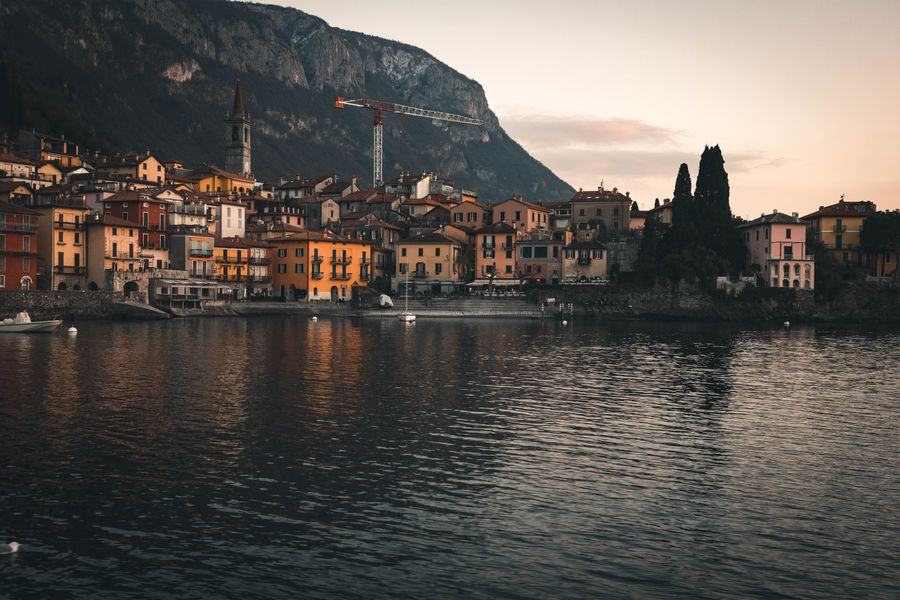 Colorful waterfront houses of a Lake Como village reflected in calm blue water