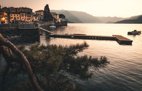 Free Tranquil sunset over Lake Como with picturesque village and dock. Stock Photo