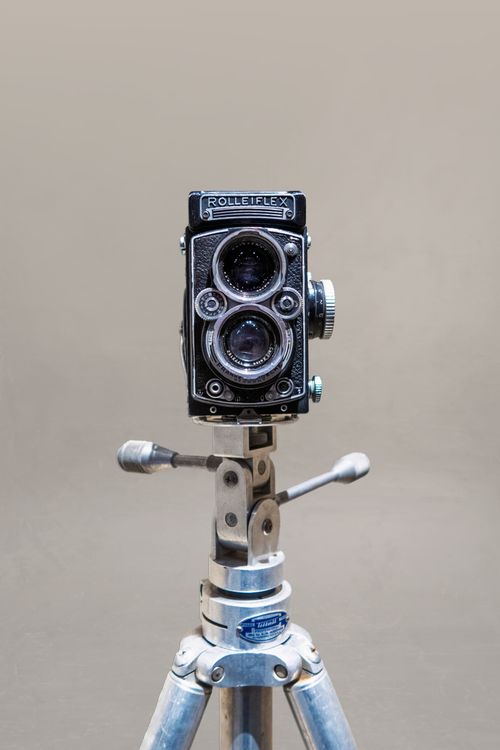 Free Classic Rolleiflex camera displayed on a metal tripod, showcasing vintage photography equipment. Stock Photo