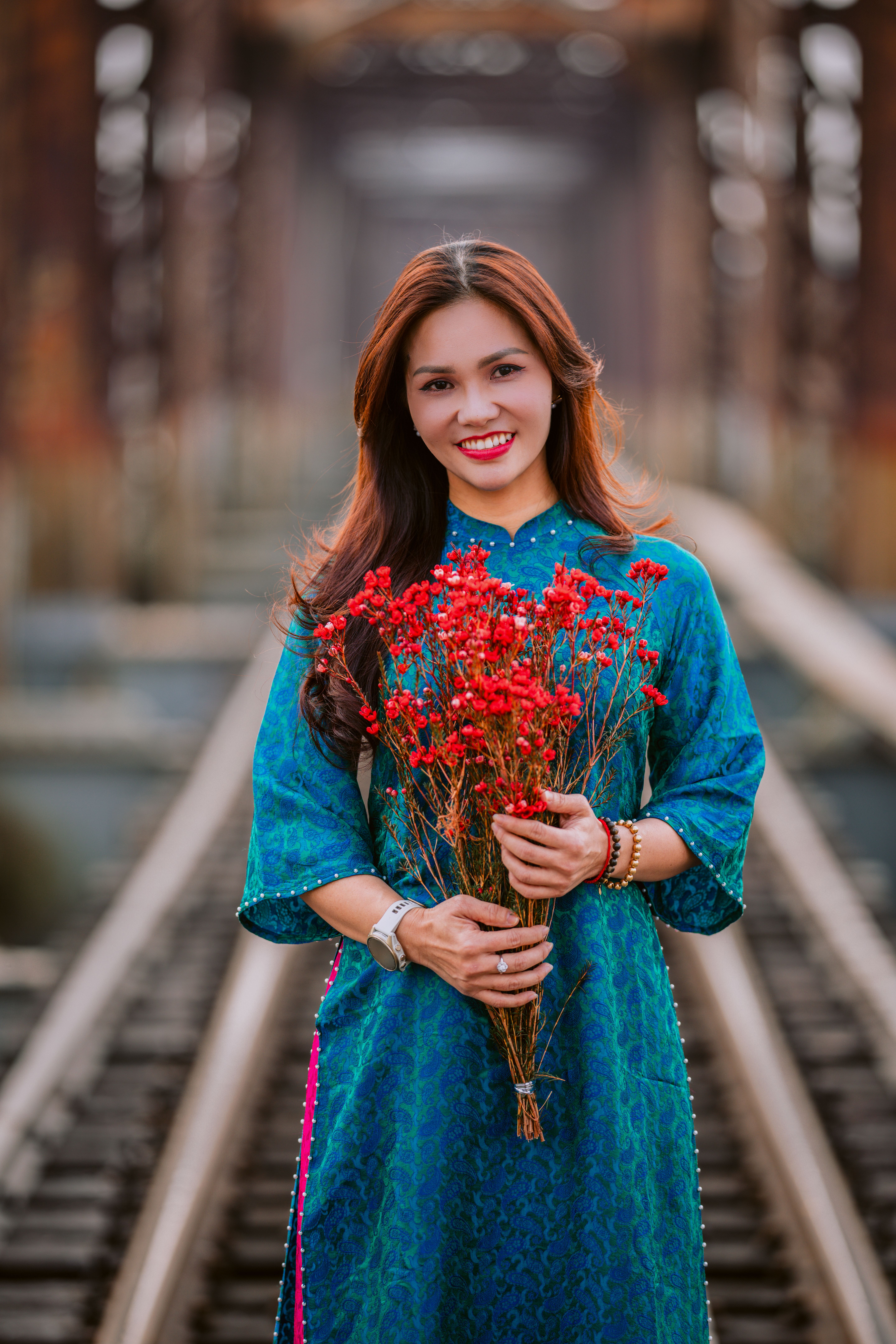 Woman in traditional blue dress holding red flowers  Free Stock Photo