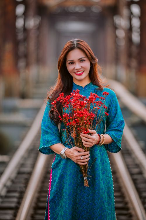 Woman in traditional blue dress holding red flowers Free Stock Photo Woman in traditional blue dress holding red flowers Free Stock Photo