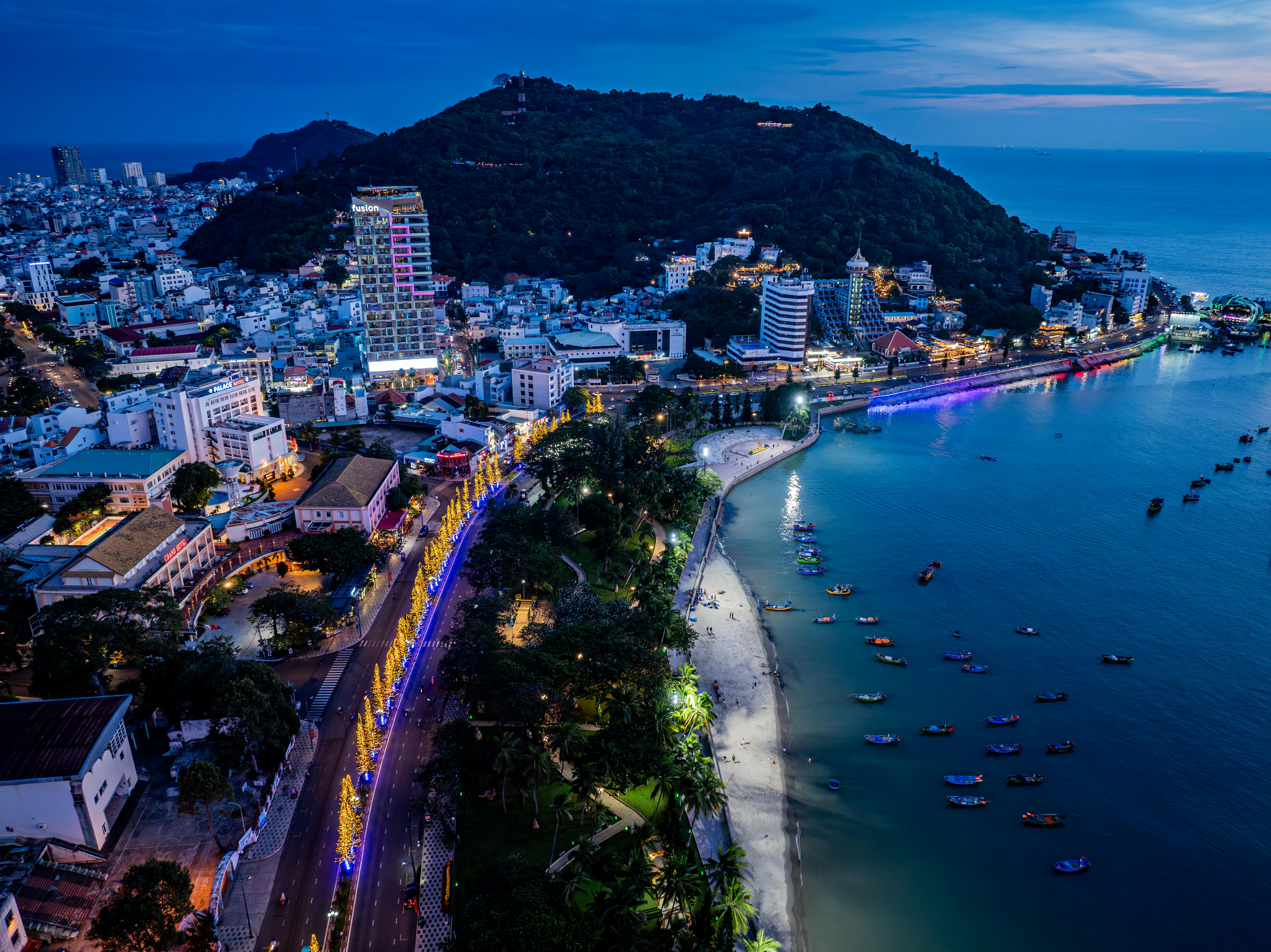 Stunning aerial view of Vung Tau city with illuminated streets and coastline at night.