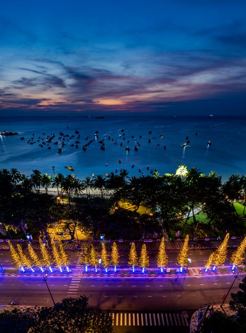 Free Aerial view of a beachfront decorated with glowing lights at dusk. Vibrant seaside scene. Stock Photo