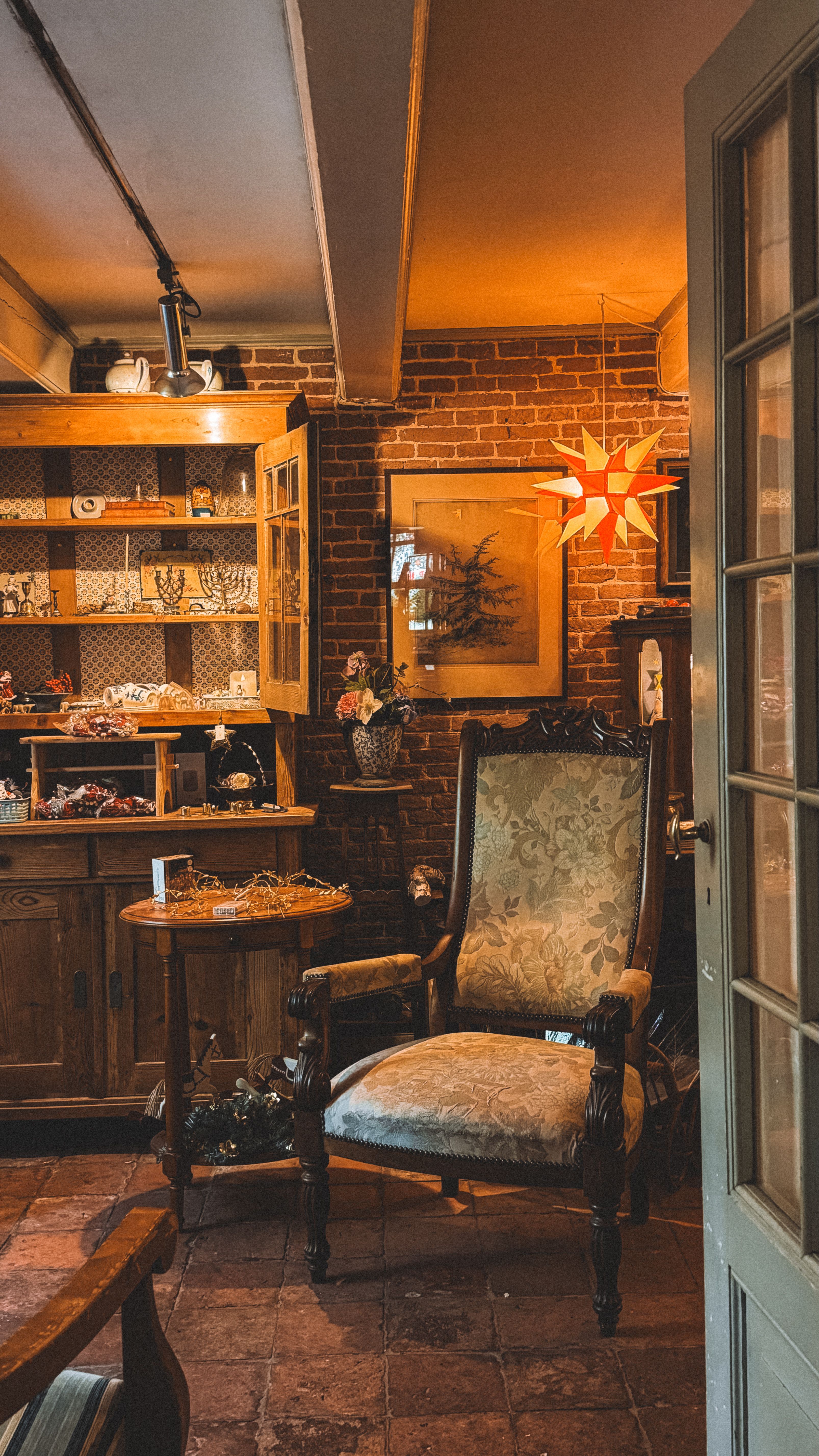 A charming vintage room featuring an antique armchair and warm ambient lighting, creating a cozy atmosphere.