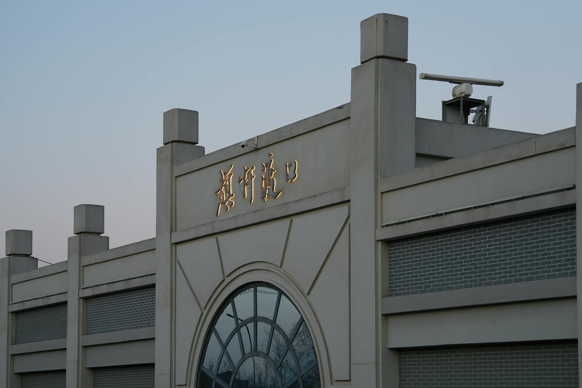 Outdoor view of a modern building with Chinese text on facade during daytime.