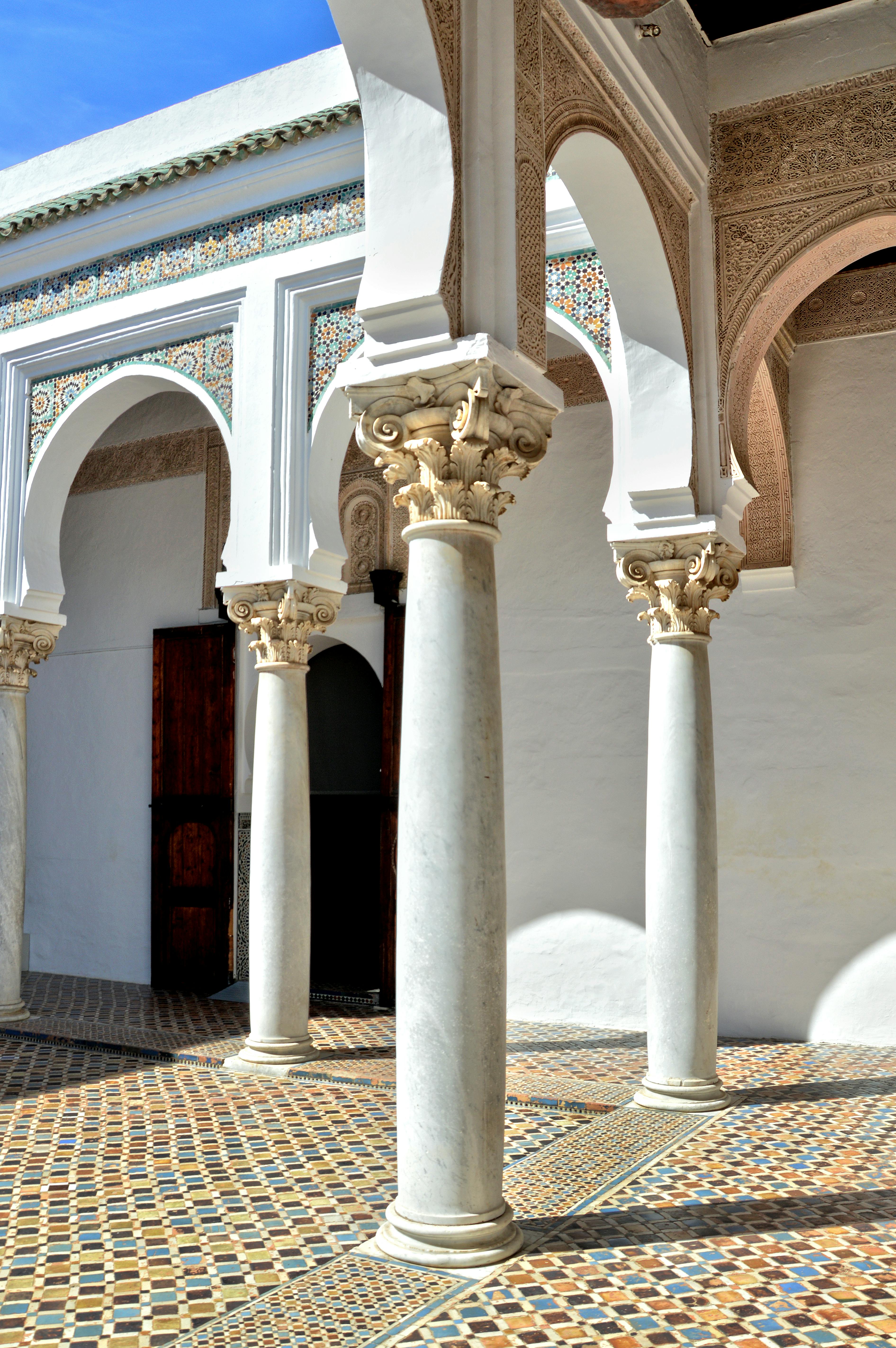 ingyenes Elegáns marokkói udvar hagyományos boltívekkel és díszes oszlopokkal, ragyogó napfényben. Stockfotó