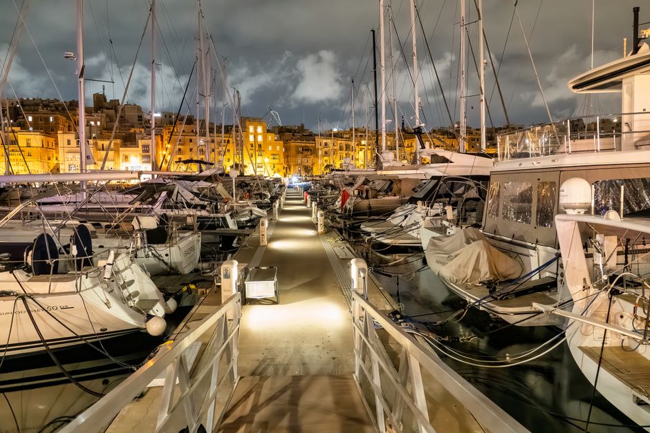 Stunning Malta Private Boat Tour: Gozo, Comino, Blue Lagoon Crystal Lagoon Review 2026 - Illuminated marina in Malta with moored yachts at night.