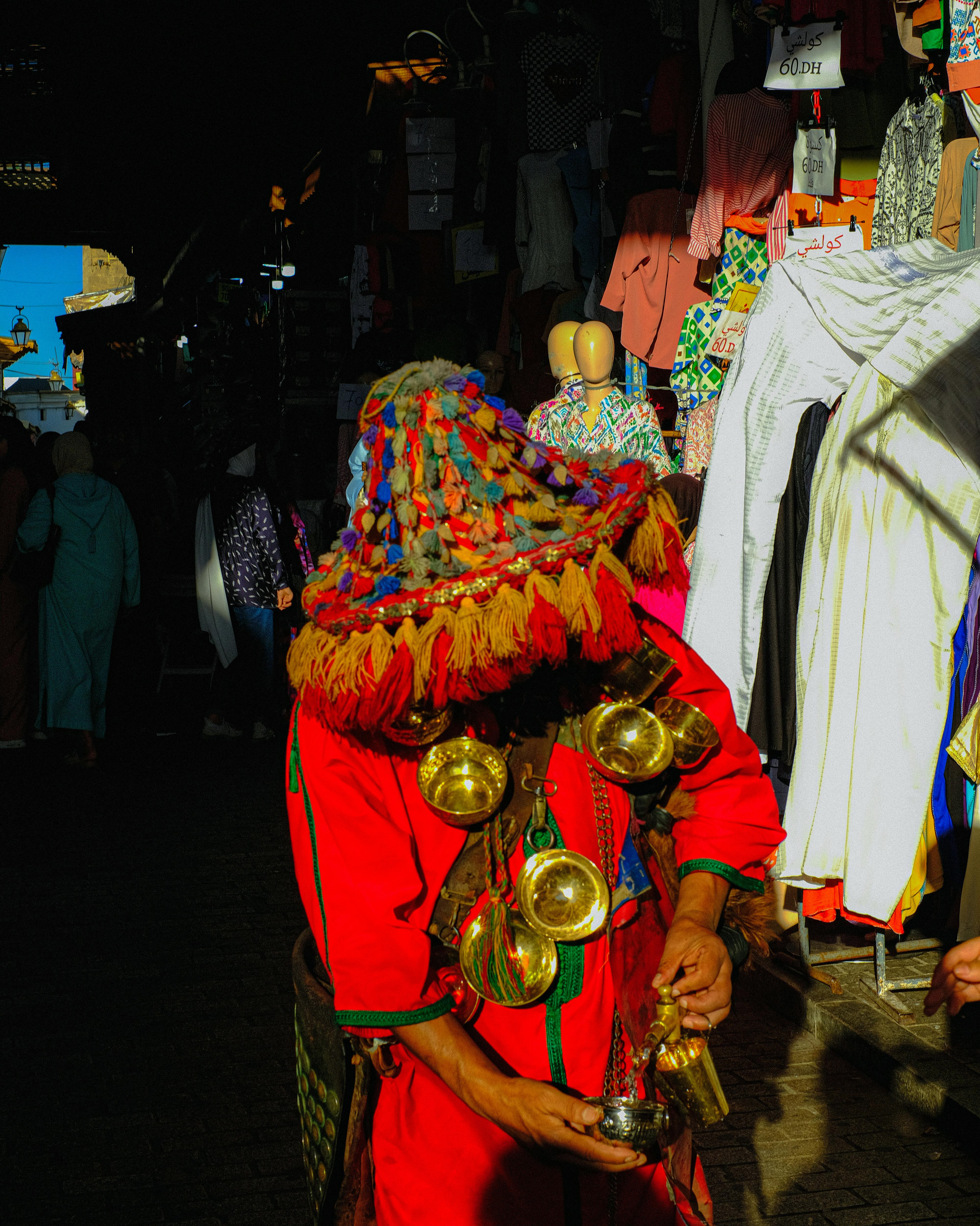 Vibrant image of a traditional water seller in a Moroccan souk, showcasing colorful attire and cultural atmosphere.