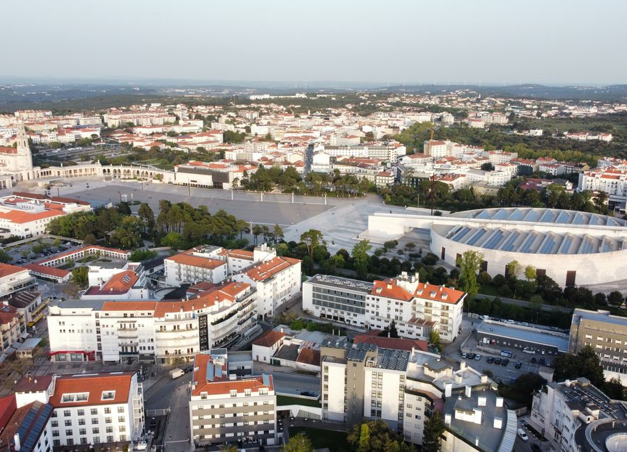 Aerial shot of Fátima Sanctuary, a renowned religious site in Portugal, surrounded by city architecture.