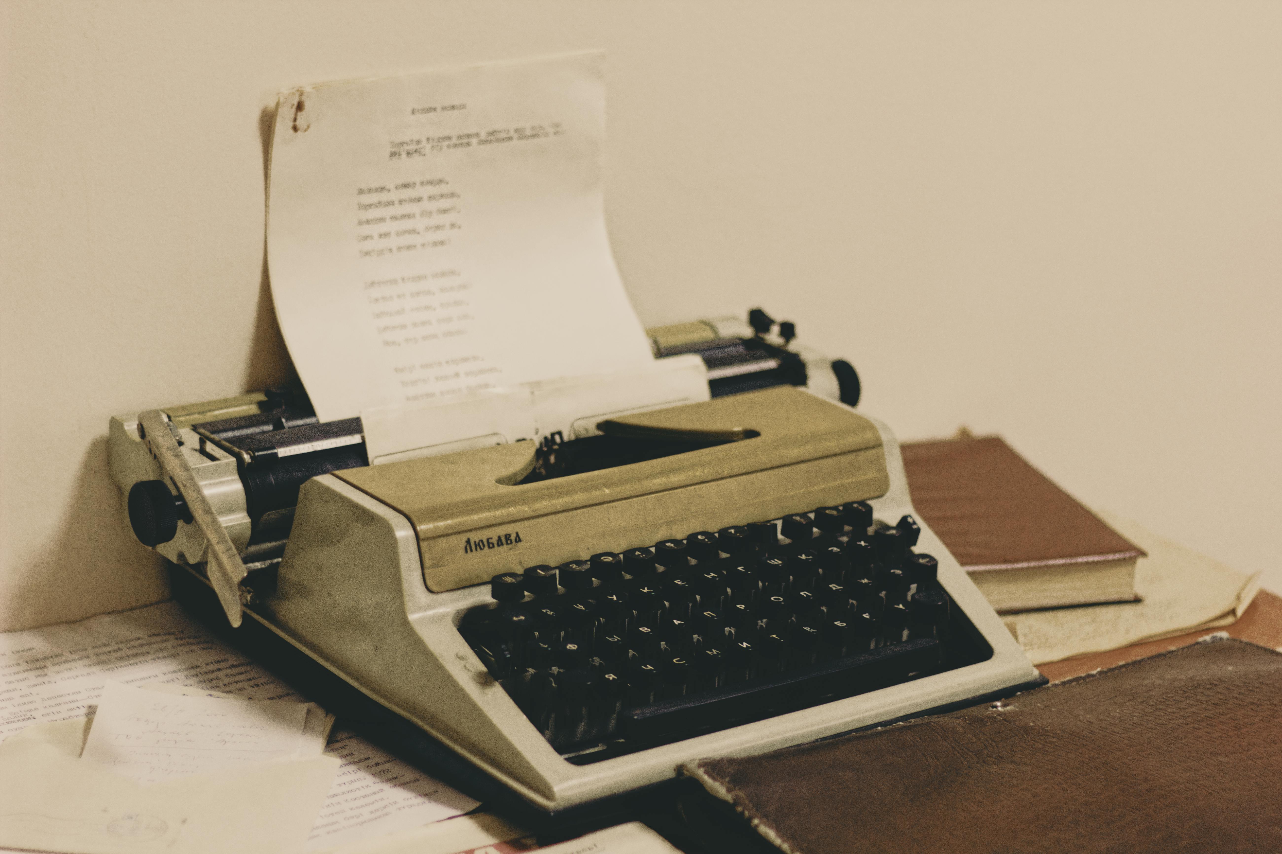 Black Typewriter Machine Typing on White Printer Paper · Free Stock Photo