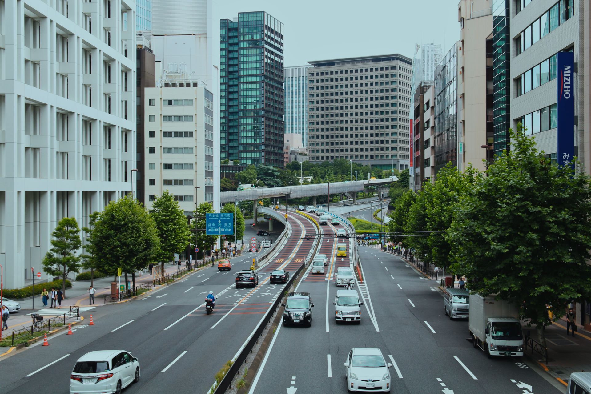 Urban view of a bustling street in Tokyo with modern skyscrapers and heavy traffic.
