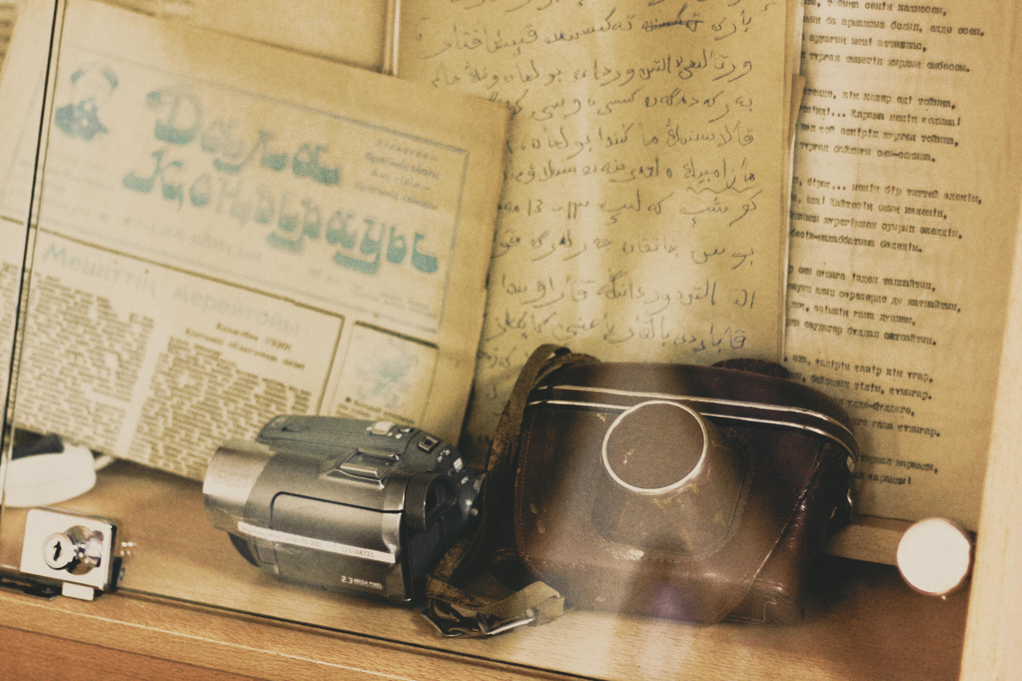 Vintage camera and script behind glass display · Free Stock Photo