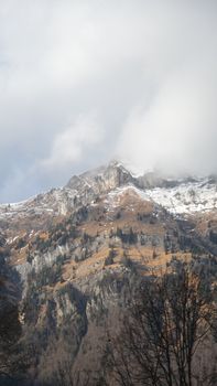 Breathtaking view of a snow-capped mountain peak partially shrouded in clouds.