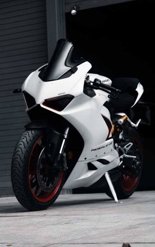 Free High-angle shot of a stylish white sports motorcycle parked indoors, exuding modern design. Stock Photo