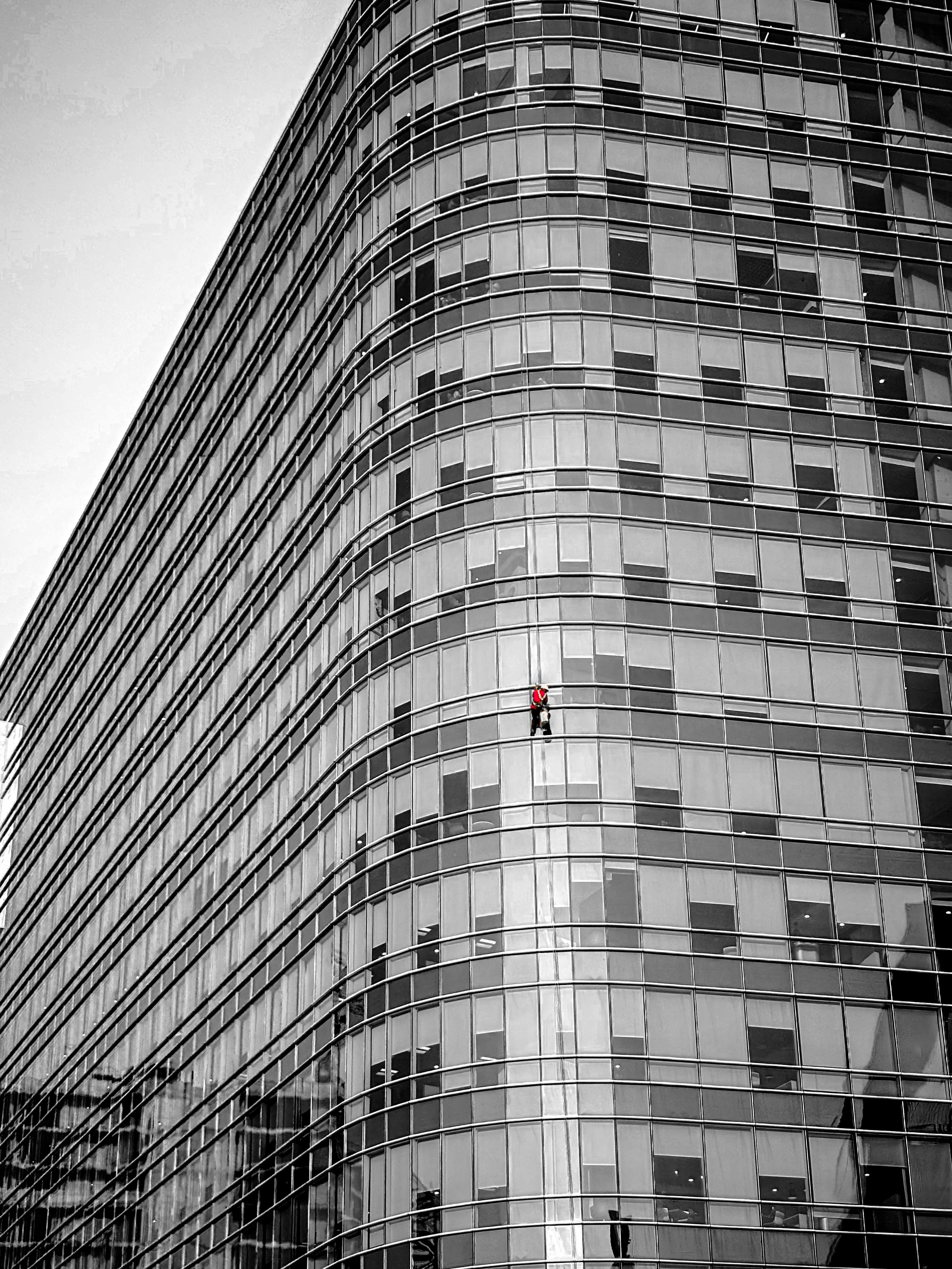 Dramatic view of a window cleaner on a modern skyscraper in Hyderabad.