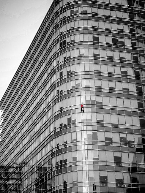 Dramatic view of a window cleaner on a modern skyscraper in Hyderabad.