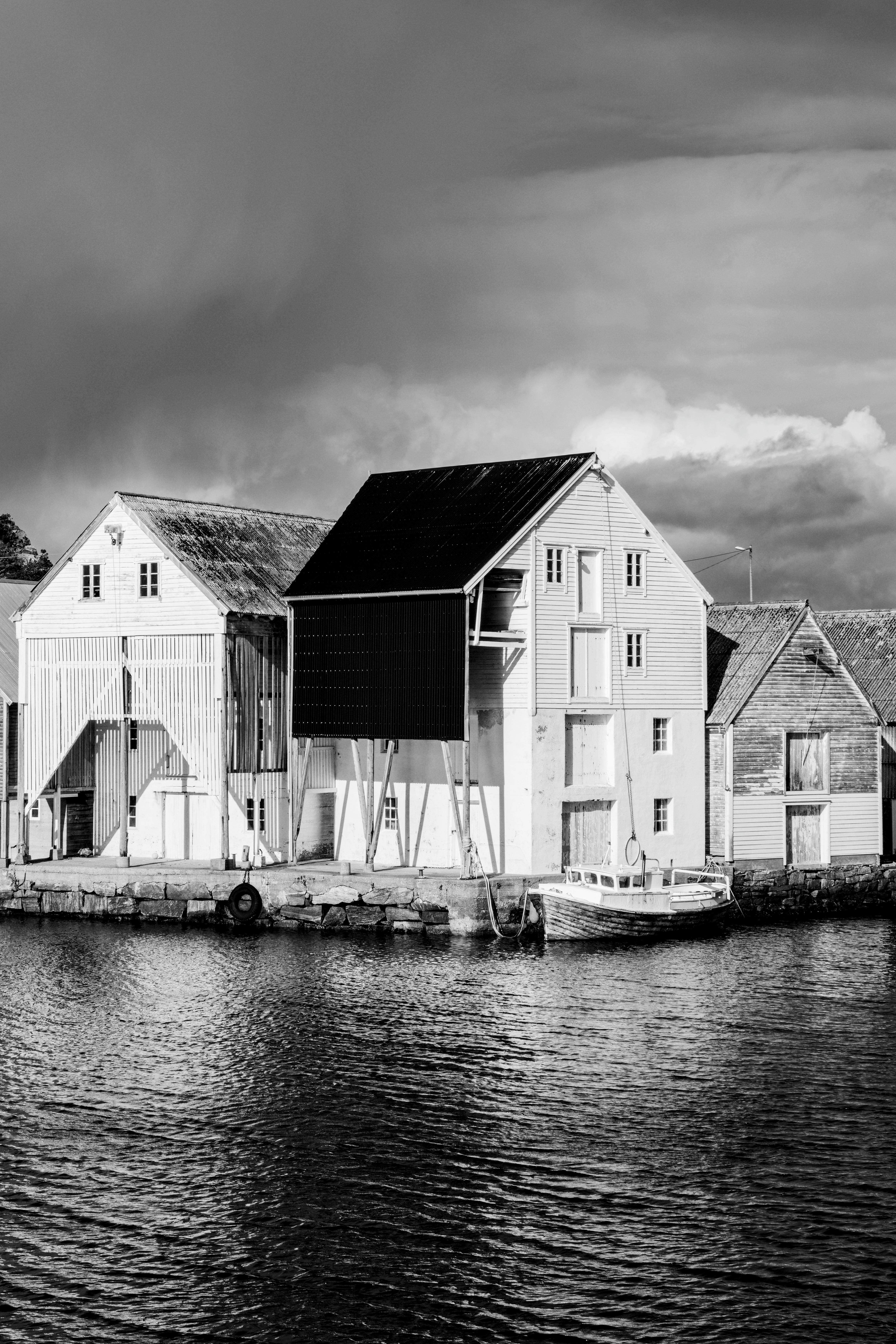 Black and white photo capturing historic waterfront buildings by the river.