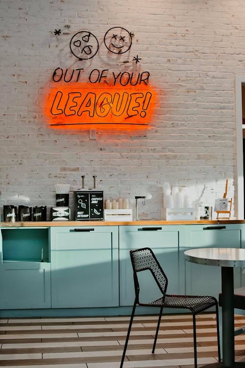 Free  A Neon Signage Hanging On A White Painted Brick Wall In A Cafeteria Stock Photo