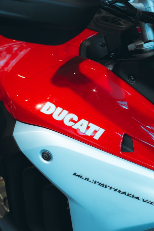 Free Detailed close-up of a Ducati motorcycle's body showcasing brand name in a modern showroom. Stock Photo