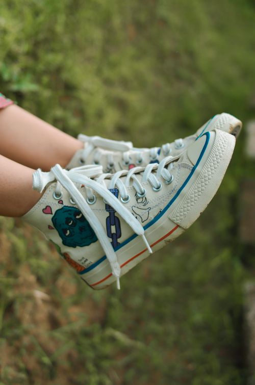 Free Stylish high-top sneakers with unique artistic designs on a natural background. Stock Photo