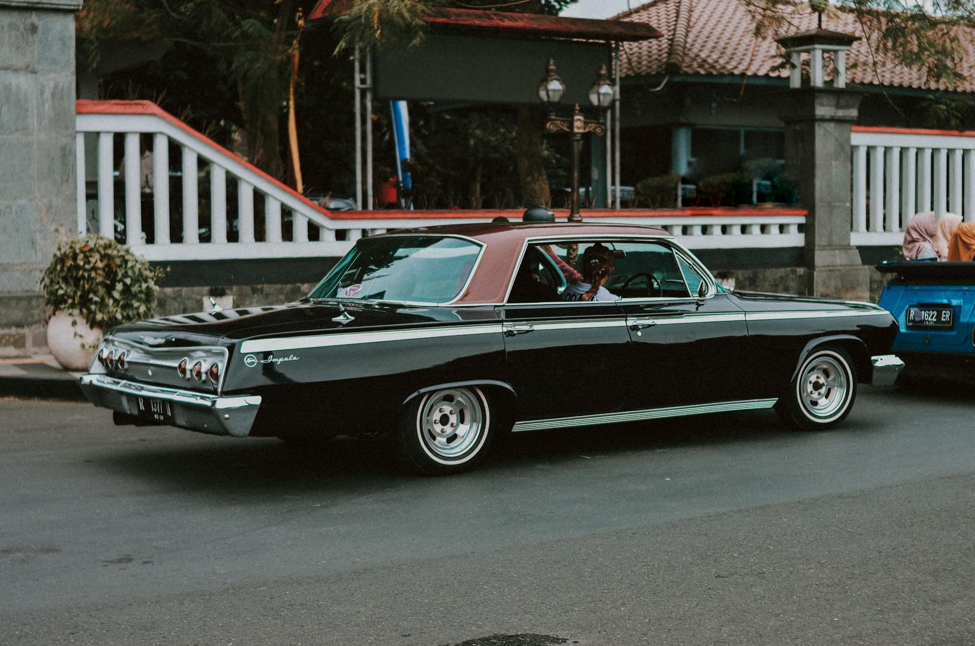 Vintage car participating in a street event in Indonesia, showcasing classic automotive style.