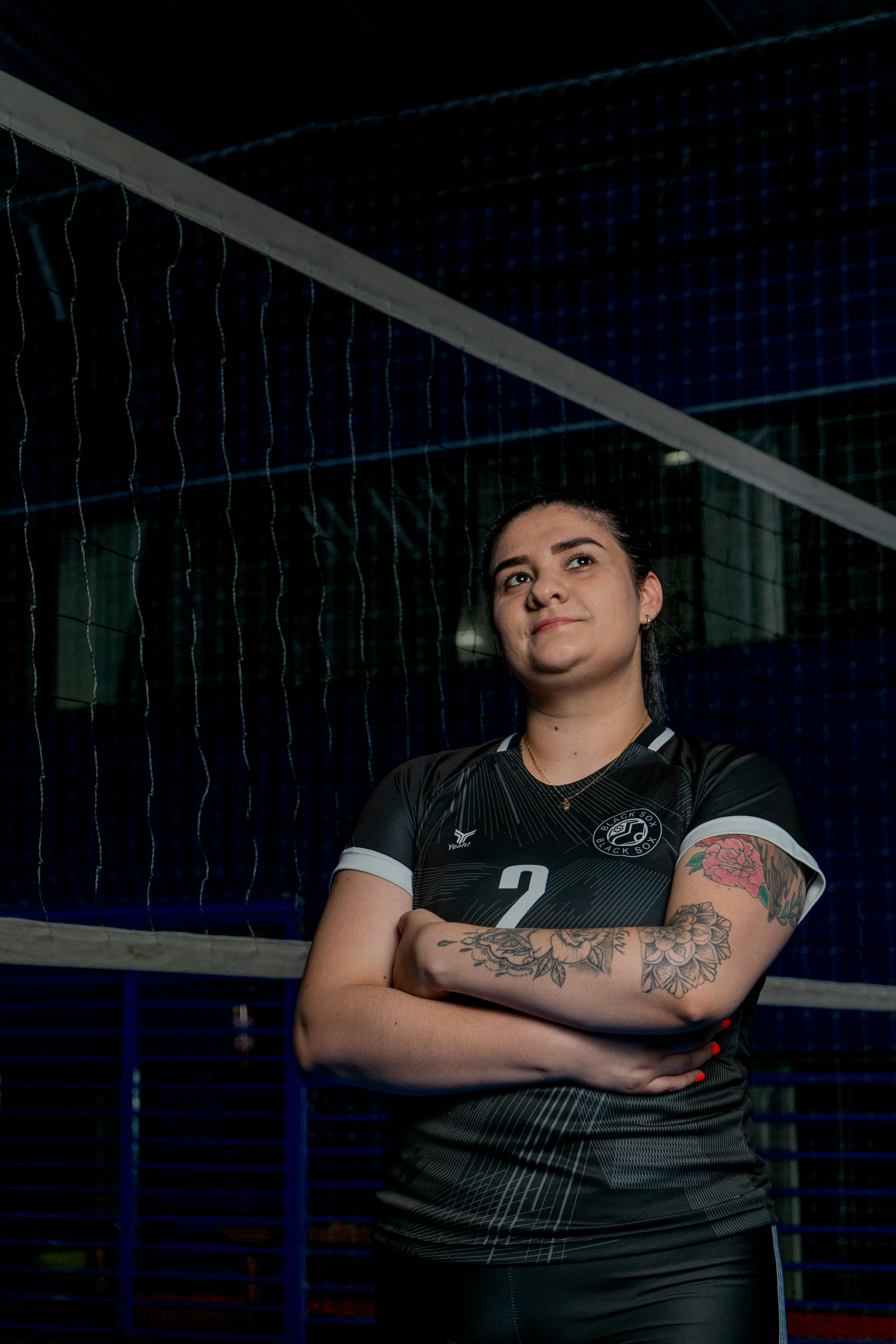 Confident female volleyball player posing indoors at Caxias do Sul sports venue.