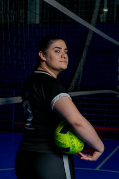Female volleyball player holding a ball indoors, Caxias do Sul, Brazil.