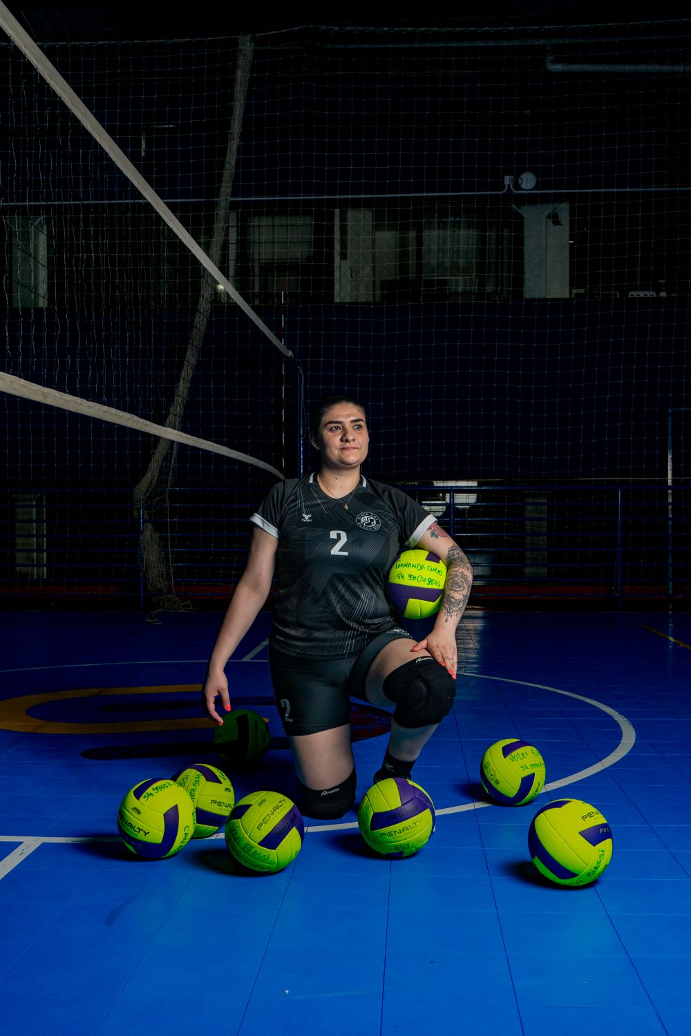 Volleyball player posing on an indoor court in training apparel