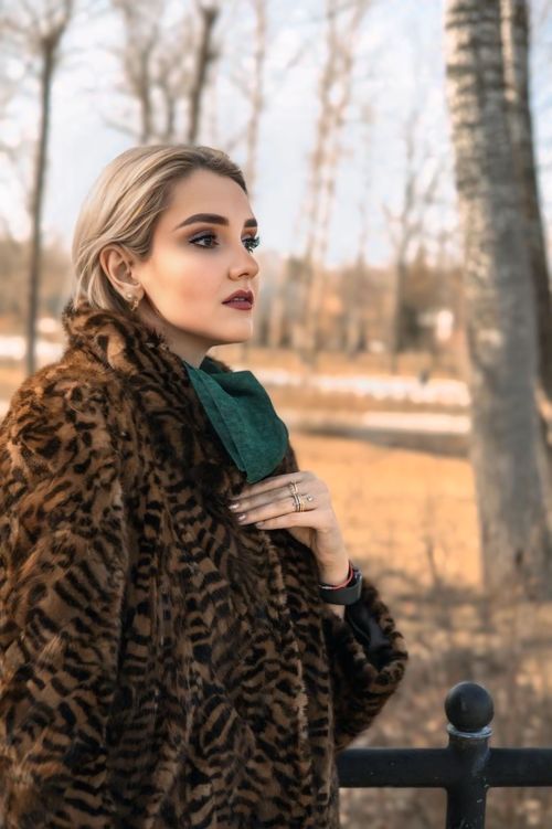 Free Elegant woman in a fur coat enjoying the outdoors in a winter setting. Stock Photo
