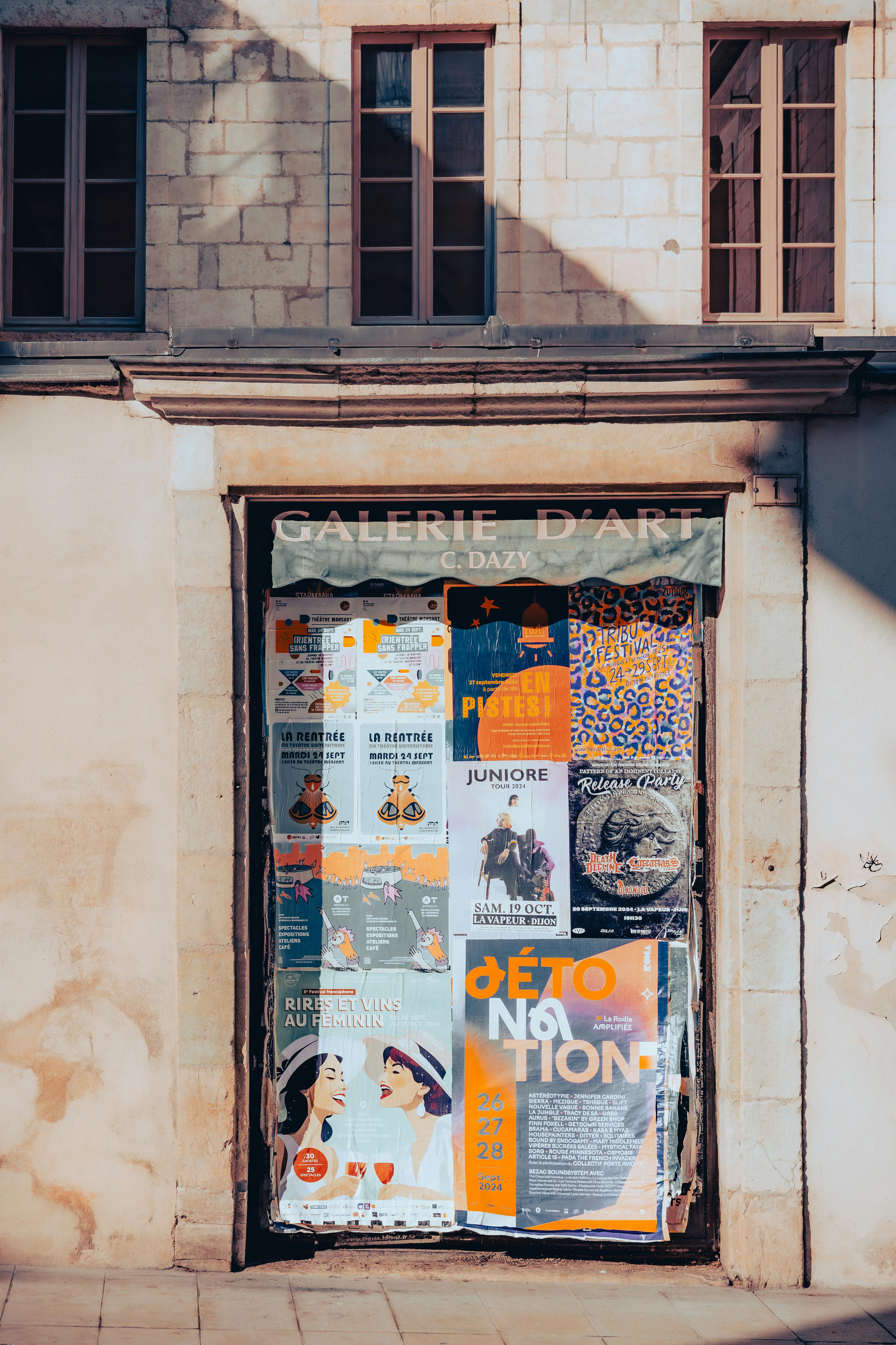 A colorful display of posters on a gallery entrance in the heart of Dijon, France.