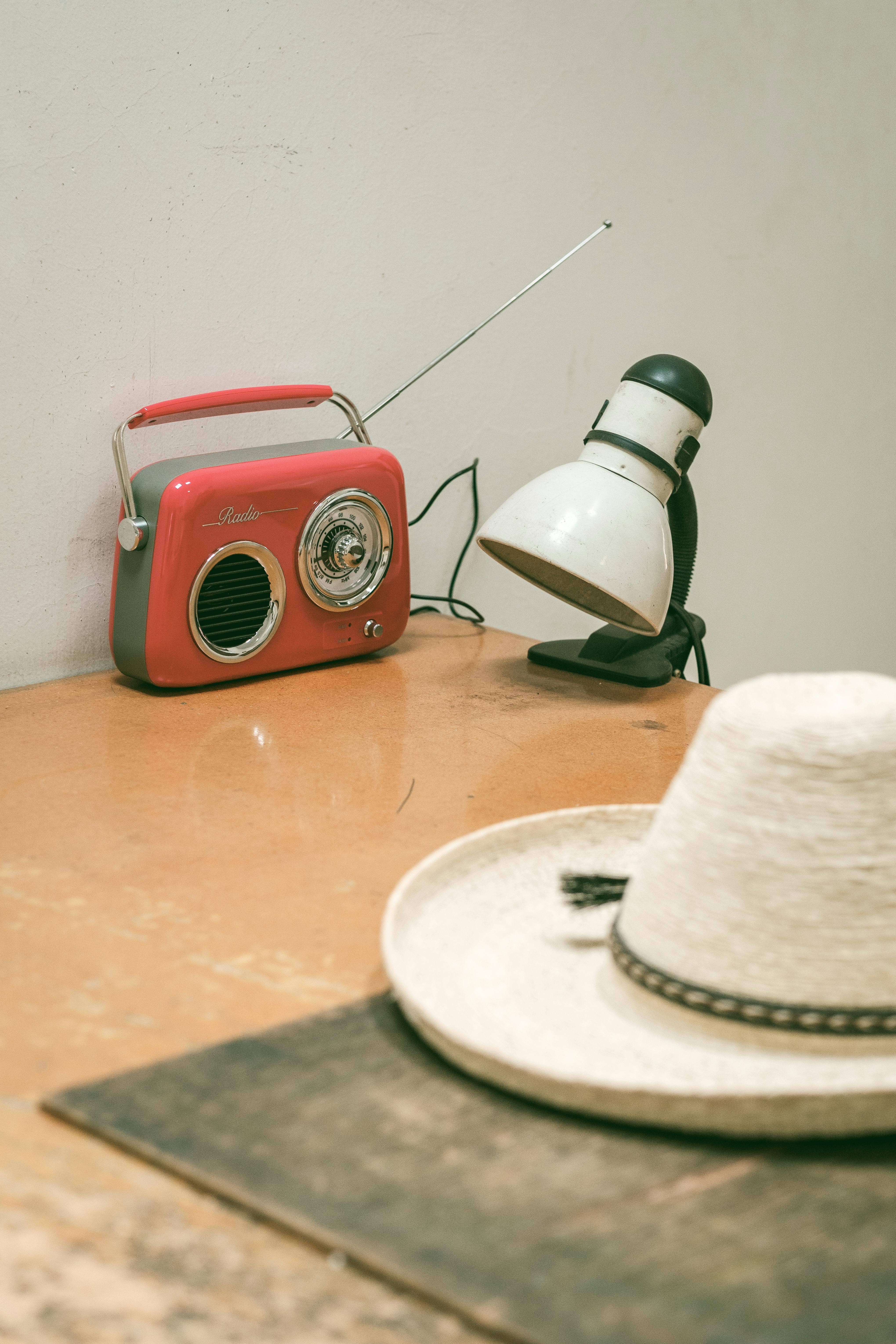 bezplatná Retro set s retro rádiem, lampou a kloboukem na dřevěném stole. Základová fotografie