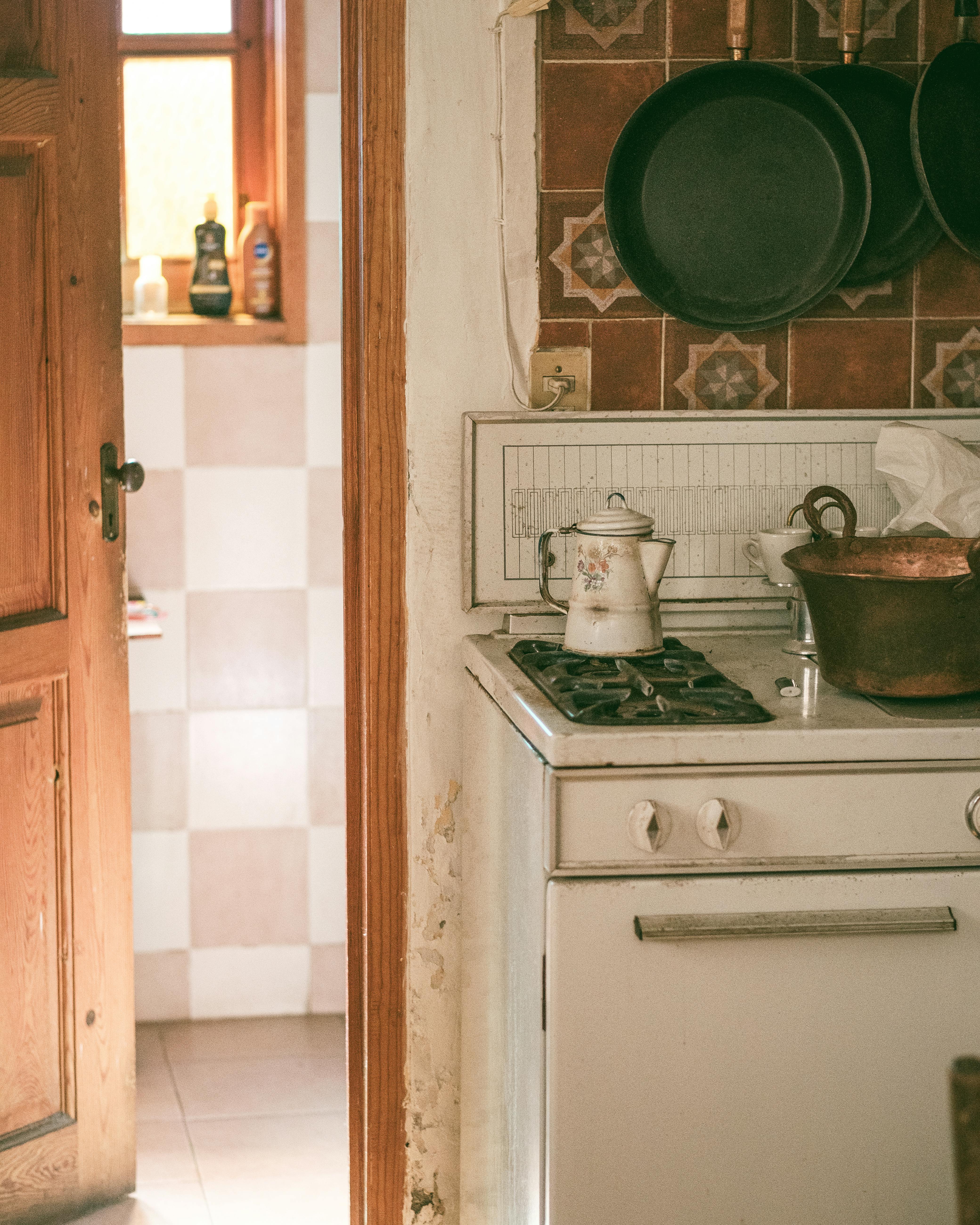 A charming rustic kitchen with vintage pans and an old stove, creating a nostalgic feel.