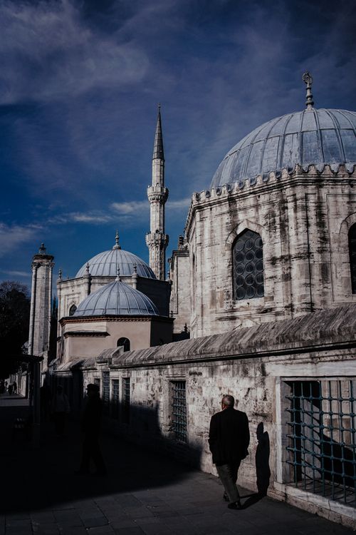 Free A historic mosque with a prominent minaret against a blue sky, showcasing Islamic architecture. Stock Photo