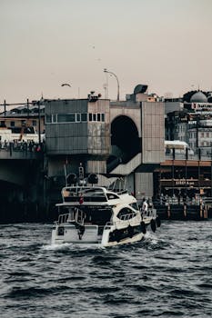 一艘时尚的游艇穿过繁华的城市港口，在黄昏的天空下展现宁静的海景