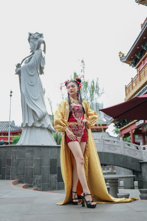 Free Woman in traditional Chinese dress posing in front of an ornate statue in Jakarta. Stock Photo