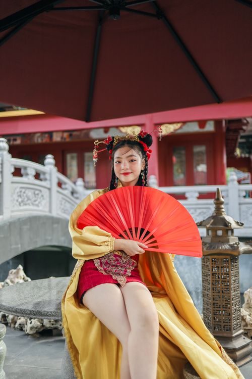Free A woman in Chinese traditional attire posing with a red fan in Jakarta. Stock Photo