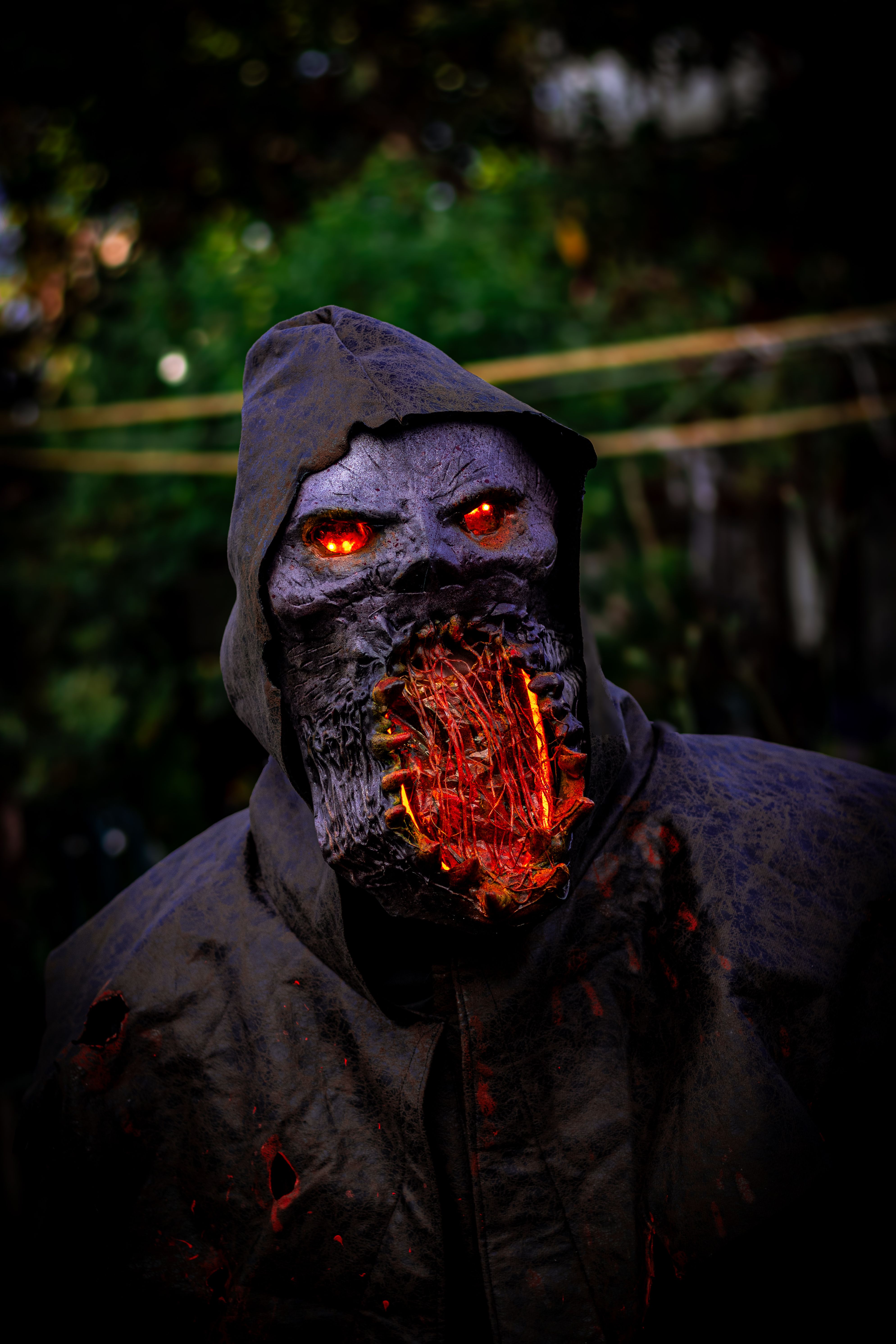A frightening monster in a dark hooded coat with fiery eyes, perfect for Halloween themes.