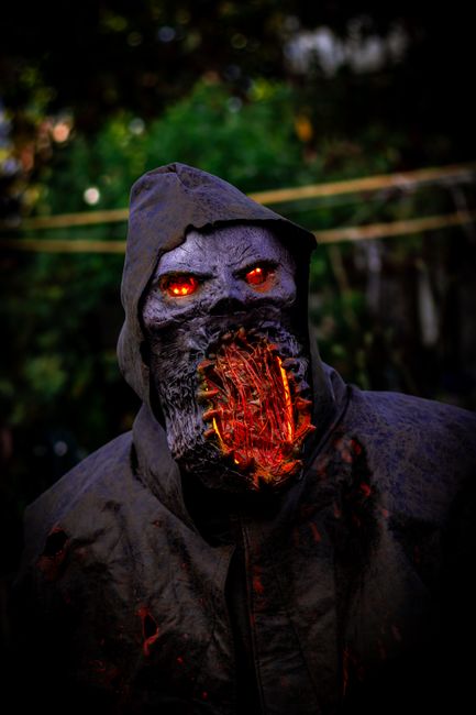 A frightening monster in a dark hooded coat with fiery eyes, perfect for Halloween themes.