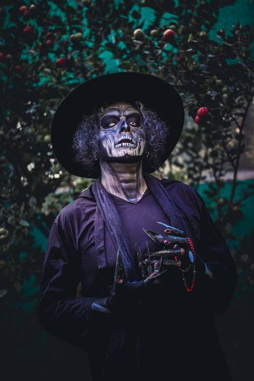 Free Person dressed in a skeleton costume for Dia de los Muertos celebration in a garden setting. Stock Photo