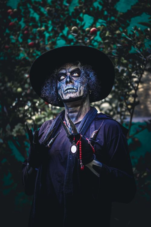 Free A person in a dramatic skull makeup and black outfit outdoors at night, evoking mystery. Stock Photo
