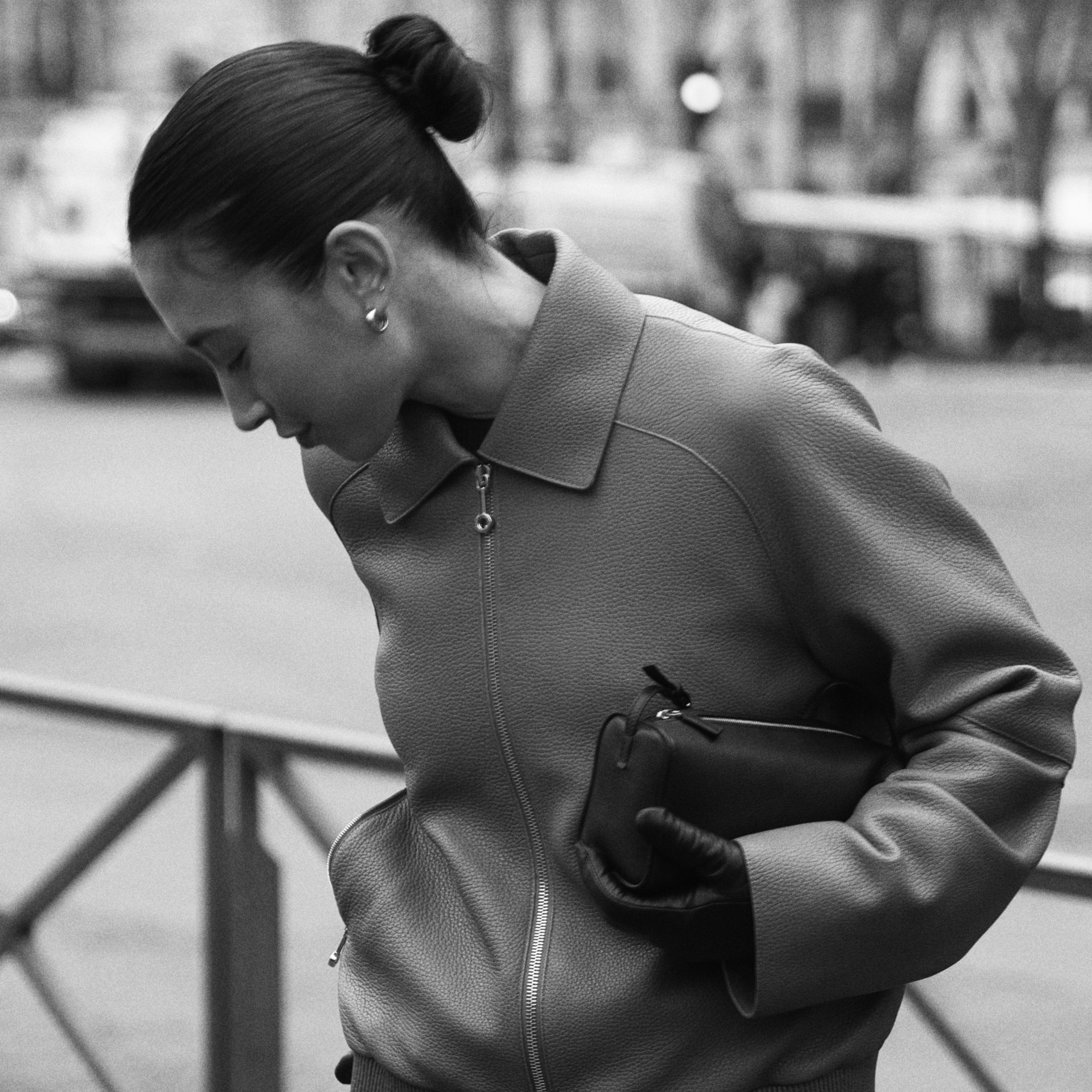 Black and white photo of a stylish woman in a Paris street, capturing elegant fashion.